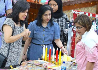 Women browsing colorful candles at Diwali Bazaar Jakarta by Gandhi Seva Loka.