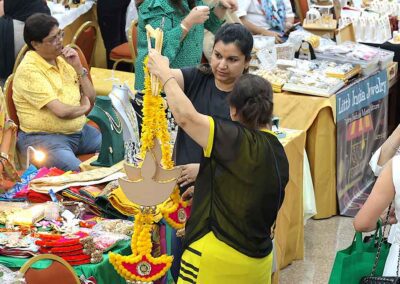 Visitors selecting traditional diya decorations at Diwali Bazaar Jakarta event.