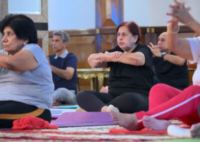 Participants in Miracle Yoga class at Gandhi Seva Loka in Jakarta performing gentle seated stretches during the weekly Wednesday wellness session.