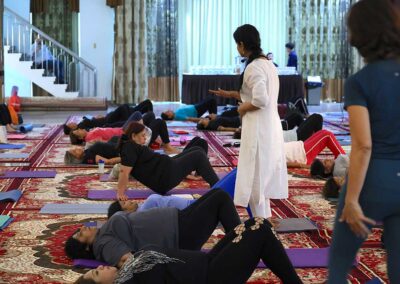 Participants lying on mats performing core-strength exercises under instructor’s guidance during Miracle Yoga class at Gandhi Seva Loka in Jakarta.