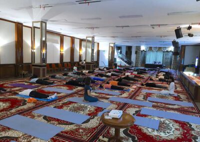 Participants lying flat in relaxation pose on mats during the closing segment of Miracle Yoga class at Gandhi Seva Loka in Jakarta.