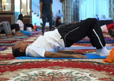 Male participant in bridge pose during Miracle Yoga class at Gandhi Seva Loka in Jakarta, focusing on back and core strength.