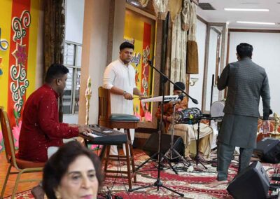 Musicians setting up keyboard, tabla, and sound equipment for Raksha Bandhan celebration by Gandhi Seva Loka.
